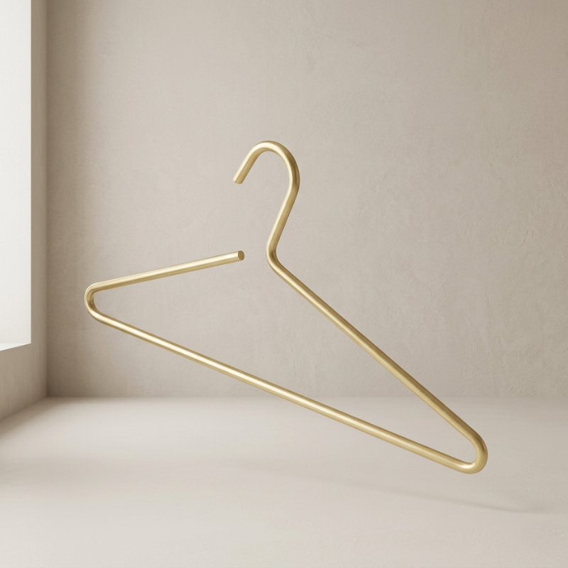 Gold metal hanger on a beige wall